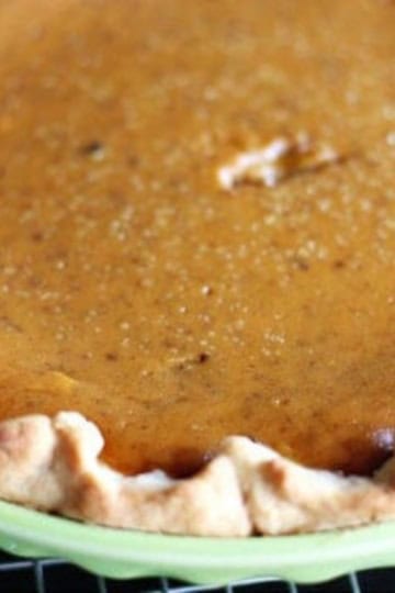 crisco pie crust with pumpkin pie filling in a green ceramic pie plate