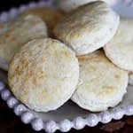 bisquick rolled biscuits stacked on a ceramic plate with a decorative edge