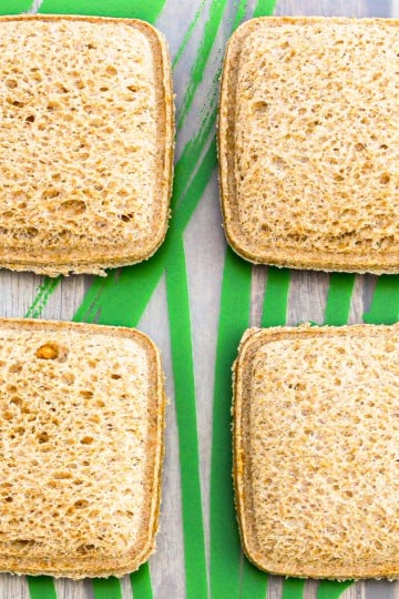 homemade uncrustables arranged on a plastic placemat printed with green leaves