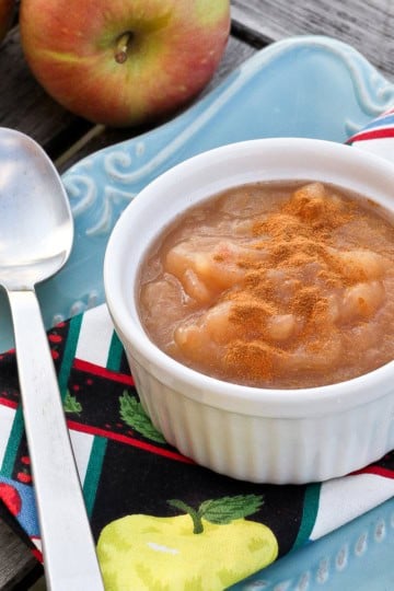 a white ceramic ramekin filled with homemade apple sauce sprinkled with cinnamon
