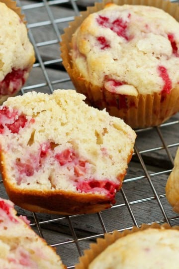 mixed berry muffins in brown muffin tin liners on a cooling rack
