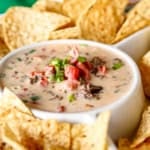 velveeta queso recipe garnished with chopped green onions surrounded by tortila chips