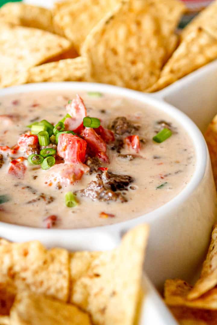white queso dip with meat served with tortilla chips