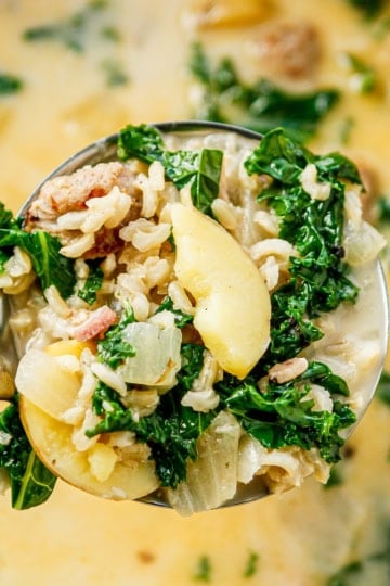 zuppa toscana soup in a ladle over a pot