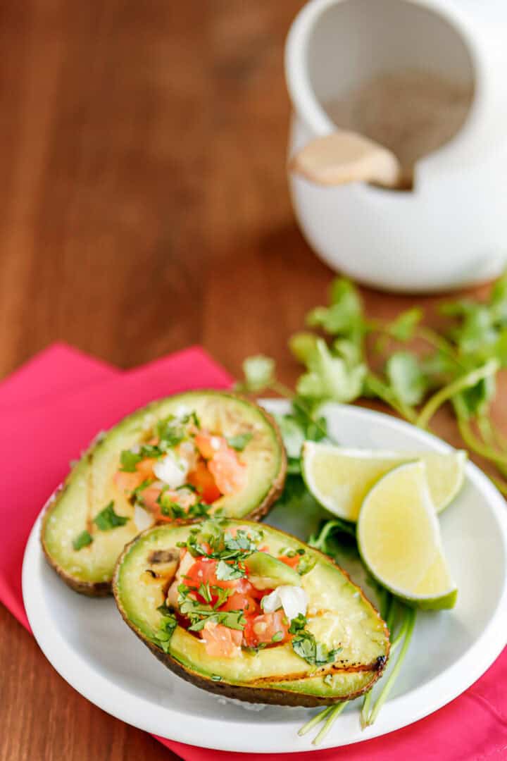 grilled avocado halves filled with fresh pico de gallo with sliced limes