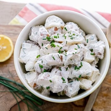 red skin potato salad with chives and a sliced lemon