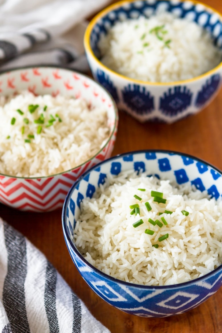 coconut milk rice in a blue and white bowl topped with chives