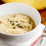 rotisserie chicken and dumplings in a bowl with fresh thyme sprinkled over top