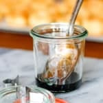 balsamic reduction in a glass weck jar with a silver spoon resting in it