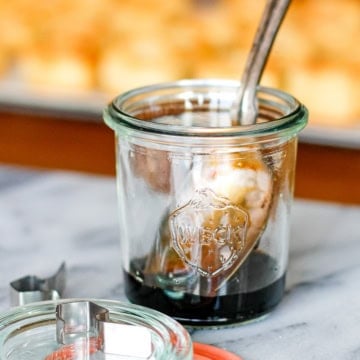 balsamic reduction in a glass weck jar with a silver spoon resting in it