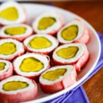 sliced pickles wrapped in cream cheese and dried beef on a platter