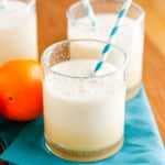 orange julius in a glass with a turquoise and white paper straw