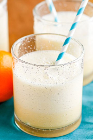 orange julius in a glass with a turquoise and white paper straw