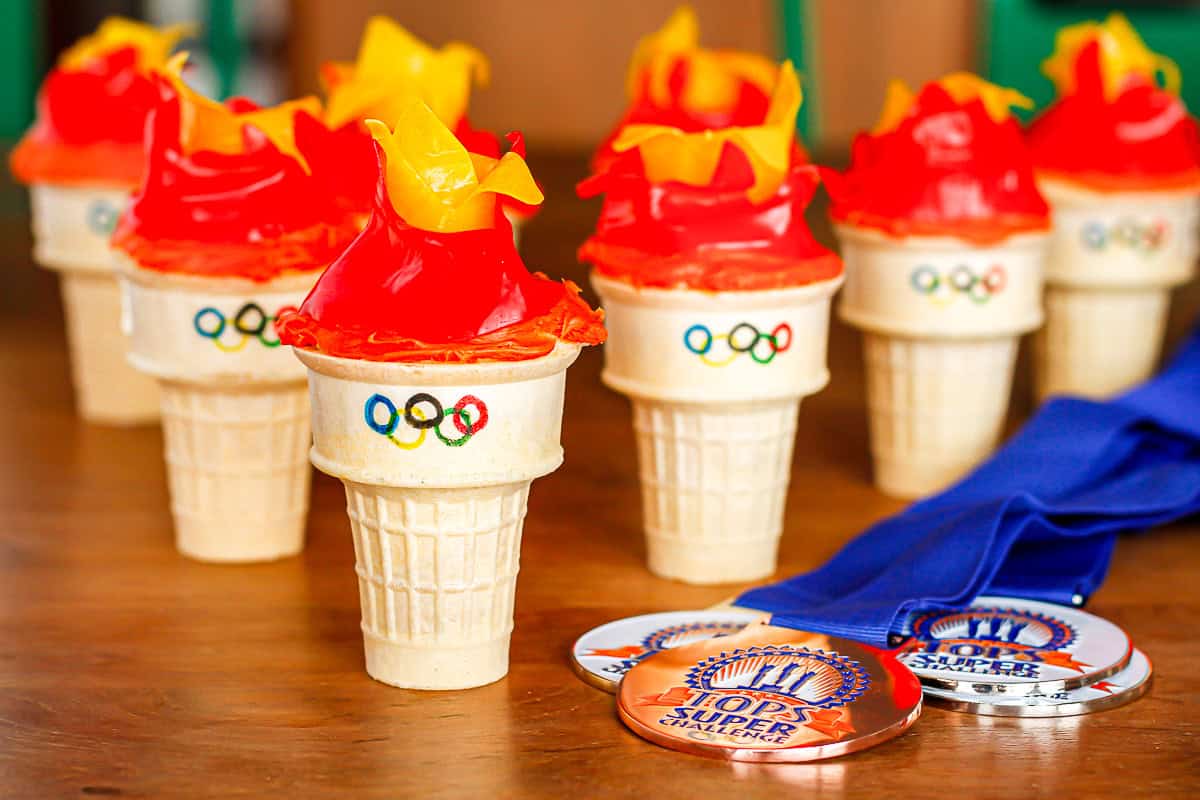 Olympic flame cupcakes lined up on a wooden table