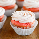fresh strawberry buttercream frosting on a pink velvet cupcake cropped square