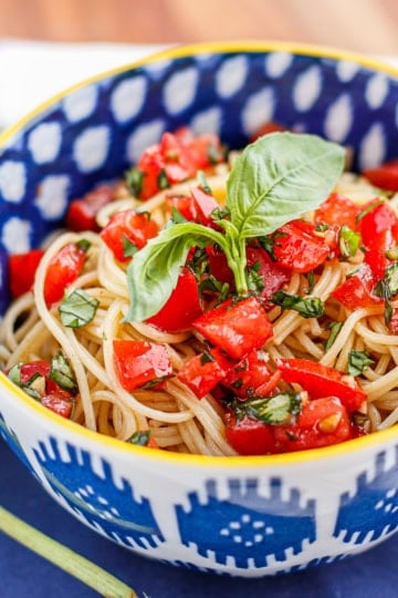 capellini pomodoro with angel hair pasta in a blue and white bowl with a yellow rim