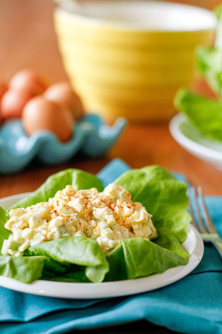 classic egg salad with celery over lettuce on a white ceramic plate