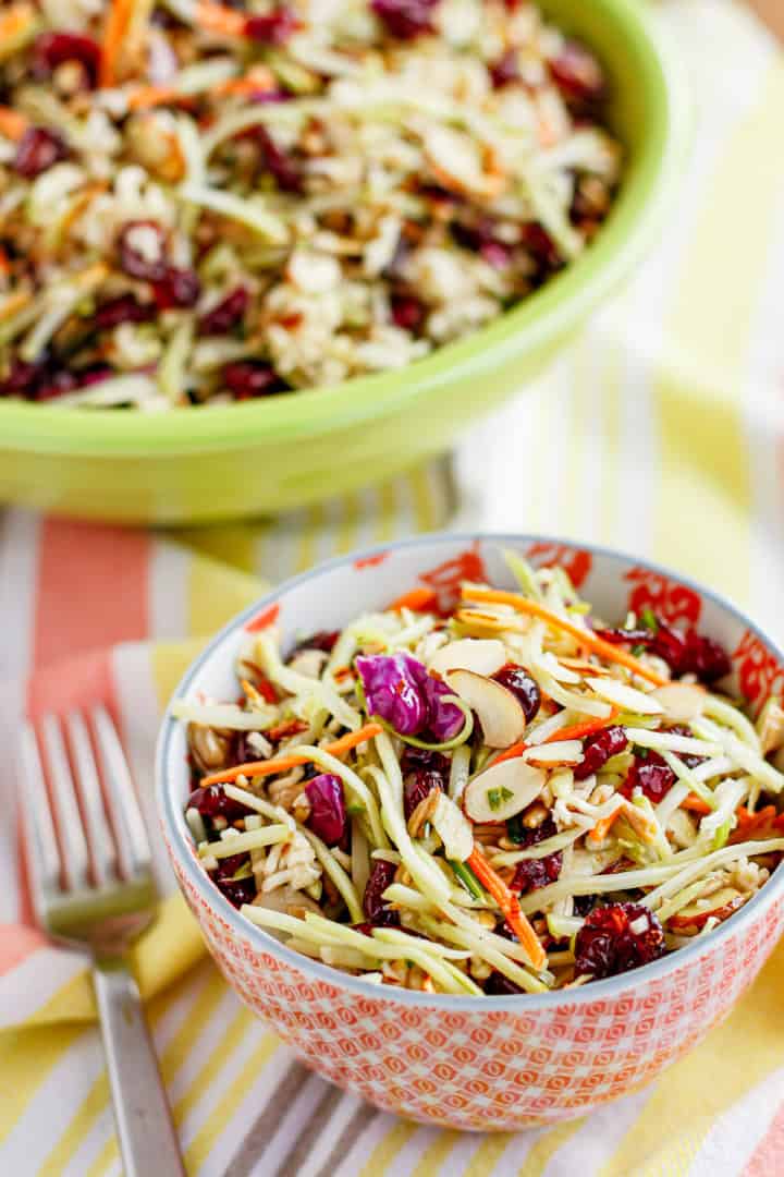 broccoli slaw with ramen noodles in a ceramic bowl with a brightly colored striped towel