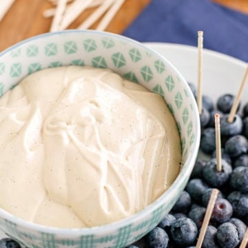 cream cheese dip for fruit in a patterned bowl with fresh blueberries