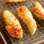 crispy baked panko chicken tenders on a wire cooling rack set on a baking sheet