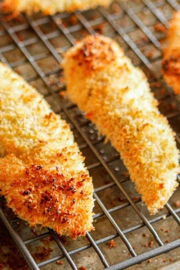 crispy baked panko chicken tenders on a wire cooling rack set on a baking sheet