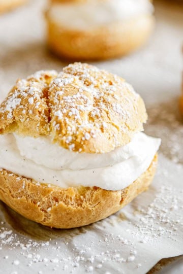 easy cream puff on parchment paper dusted with powdered sugar