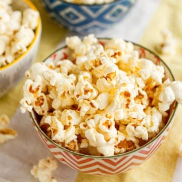 homemade movie popcorn at home drizzled with clarified butter in ceramic bowls