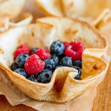 tortilla bowl filled with fresh blueberries and raspberries drizzled with honey