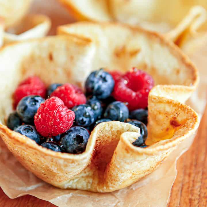 tortilla bowl filled with fresh blueberries and raspberries drizzled with honey