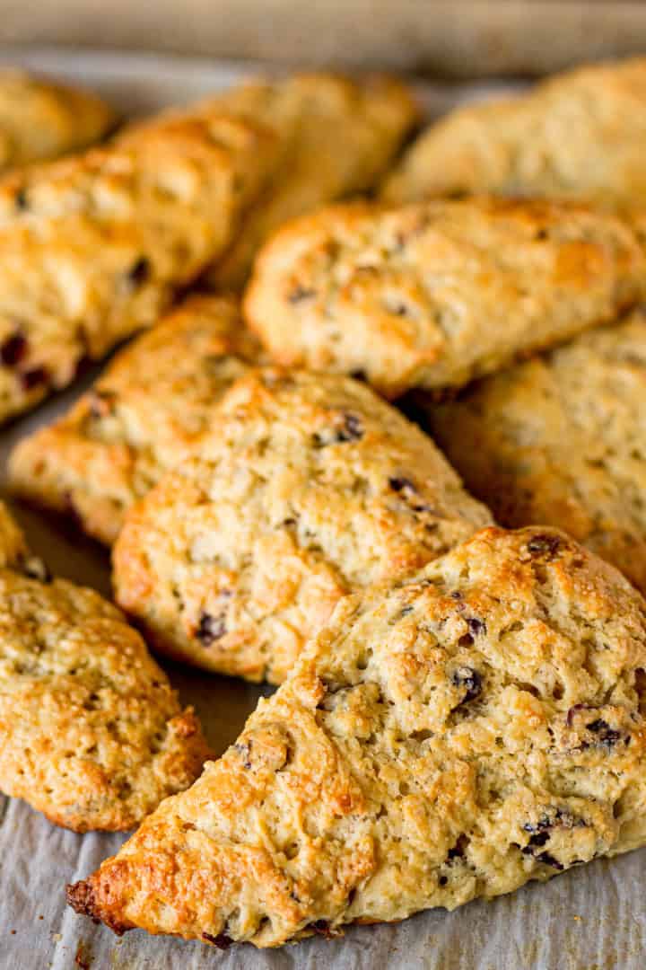baked cranberry scones piled on a sheet of parchment paper