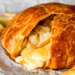 warm baked brie in a crescent roll with apples served with fresh apple slices