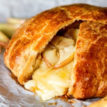 warm baked brie in a crescent roll with apples served with fresh apple slices
