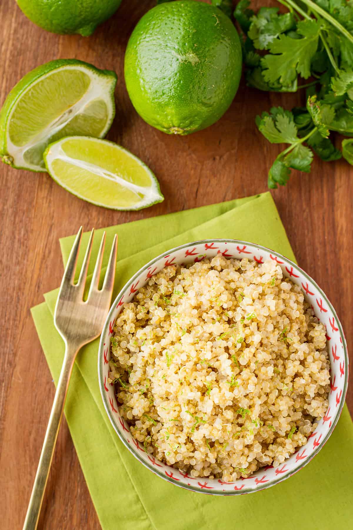 coconut milk quinoa with lime zest in a bowl with limes and a fork