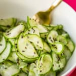 Asian cucumber salad recipe with a gold fork and fuschia napkin