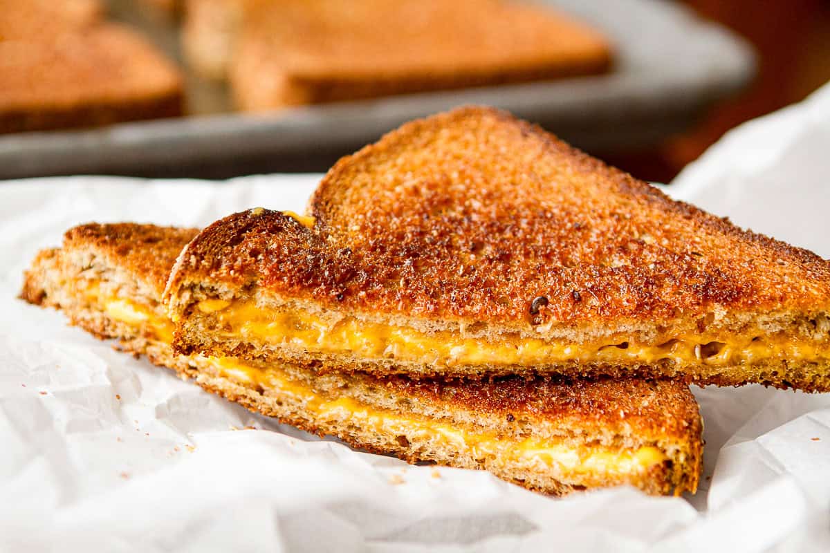 oven baked grilled cheese sliced on crinkled parchment paper