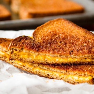 sliced grilled cheese sandwich on parchment paper