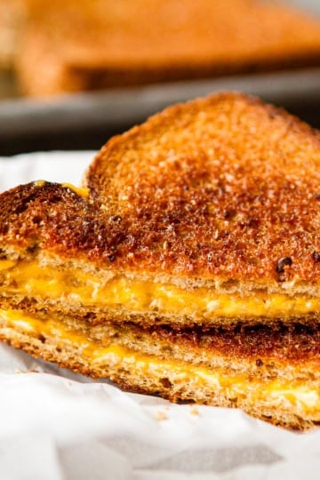 sliced grilled cheese sandwich on parchment paper