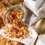 crunchy honey granola in a glass jar with a gold spoon