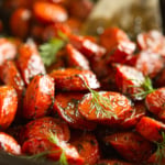 honey roasted carrots garnished with fresh dill in a black iron skillet