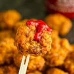 cheese sausage balls without bisquick on a bamboo pick with srirache drizzled on top