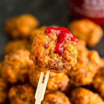 cheese sausage balls without bisquick on a bamboo pick with srirache drizzled on top