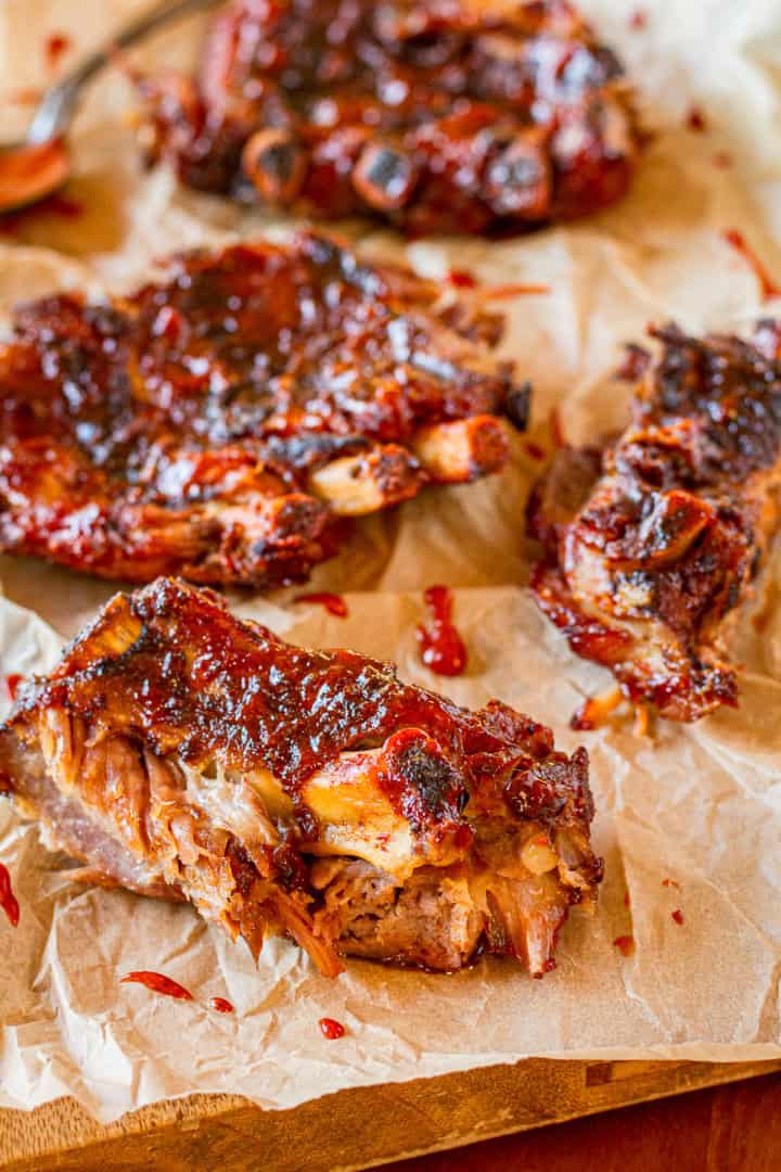 grilled crockpot ribs with bbq sauce arranged on brown parchment paper