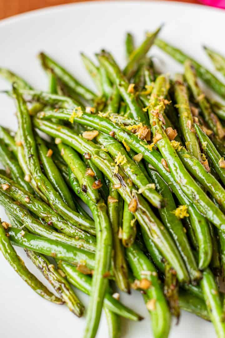 sauteed fresh green beans with garlic and lemon zest on a white plate