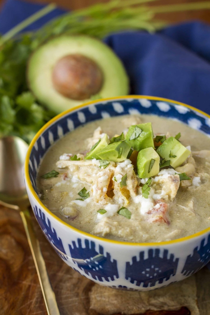 instant pot chili chicken verde in a colorful ceramic bowl topped with diced avocado and cilantro