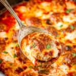 meatball casserole recipe being scooped out with a silver spoon