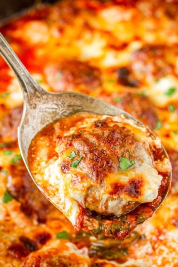 meatball casserole recipe being scooped out with a silver spoon