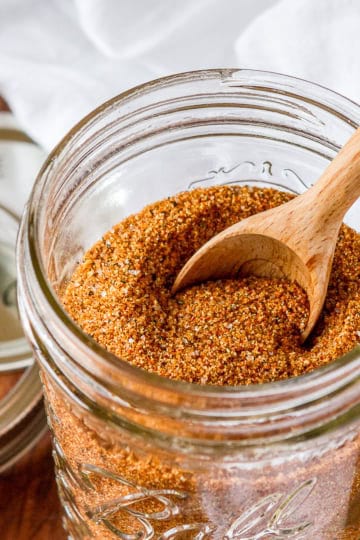 pork rub recipe in a mason jar with a wooden measuring spoon