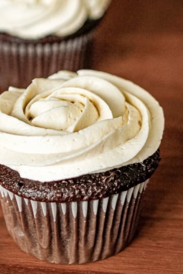 a chocolate cupcake with whipped icing piped in the shape of a rosette on top
