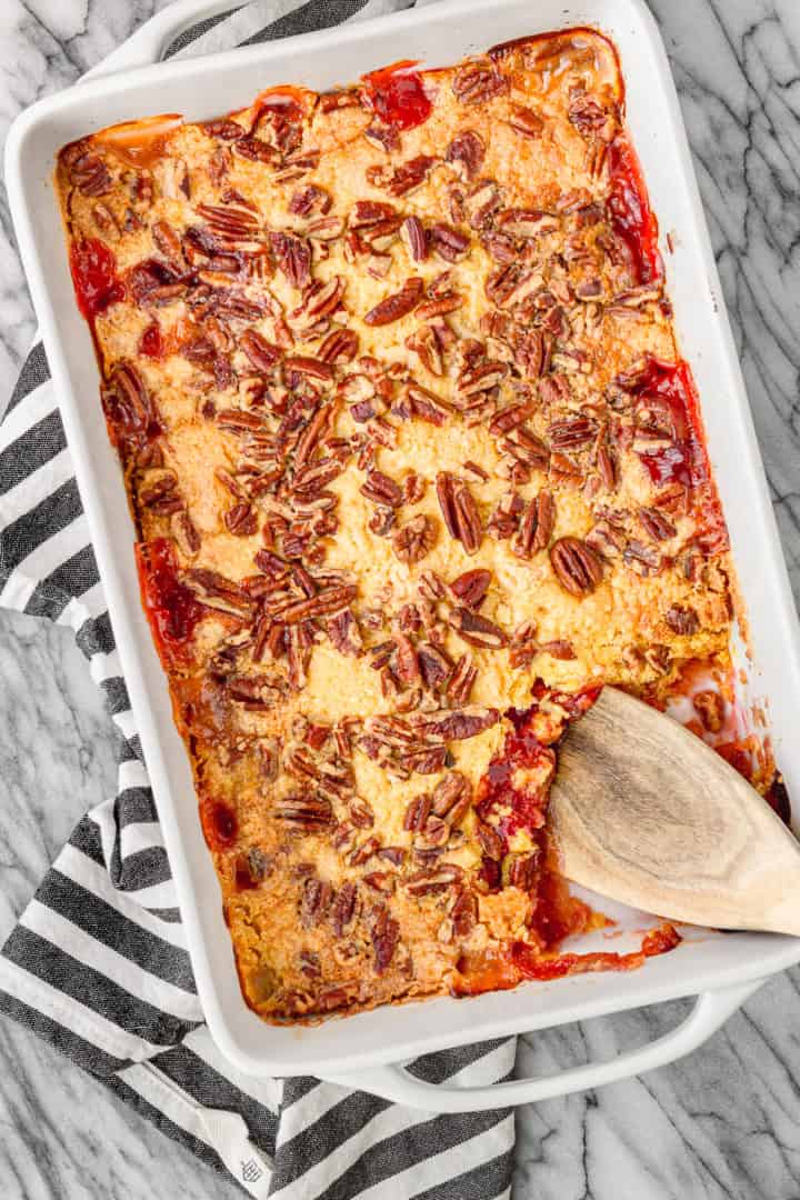 easy cherry pineapple dump cake made with just 5 ingredients in a white ceramic baking dish