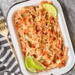 easy salsa chicken recipe garnished with cut limes in a white enamel dish